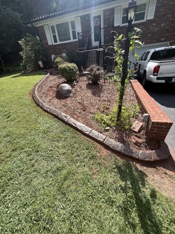 Completed decorative curbing around the front garden of a brick home