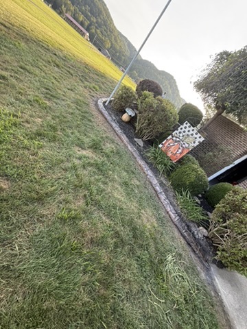 After: Decorative edging frames the planting bed around the flagpole.