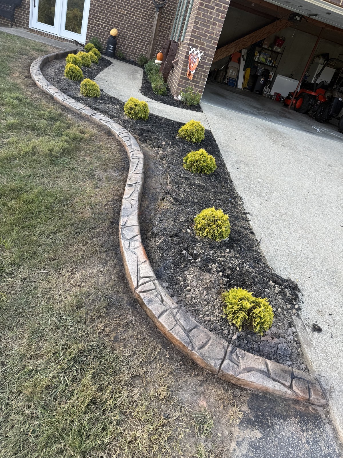 After: New decorative curbing follows the curves of the front planting bed.