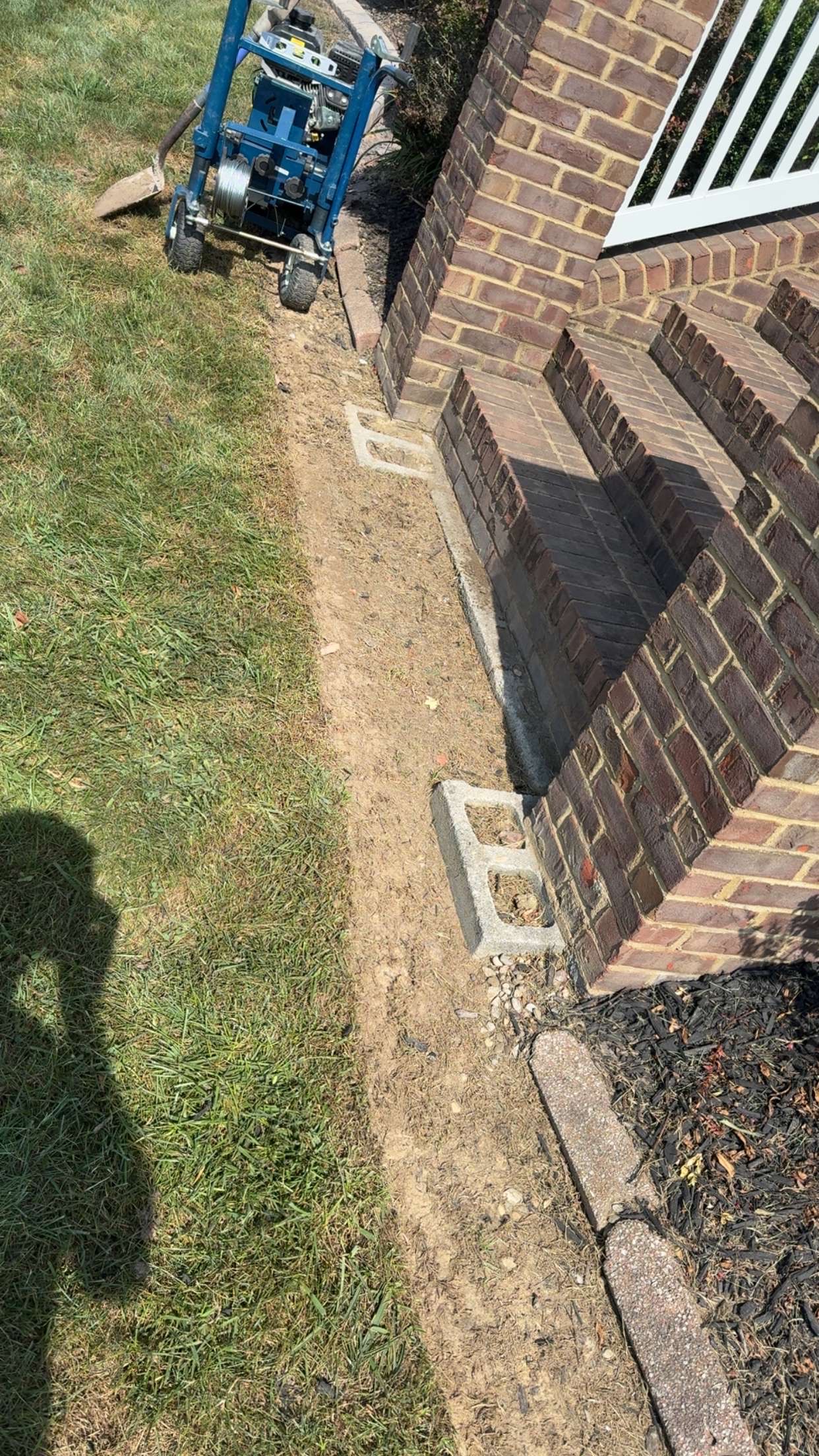 Prepared ground beside brick steps before decorative concrete work